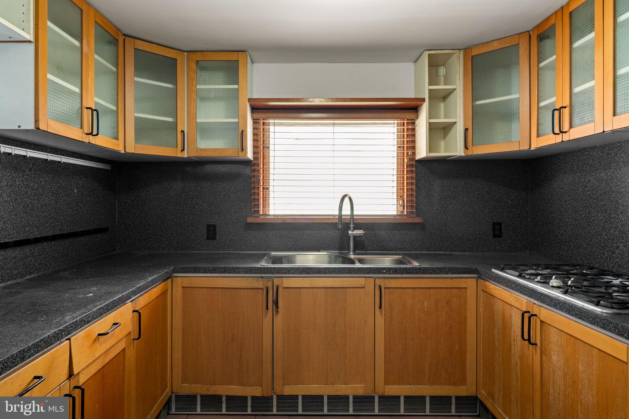 3633 Warren Street Philadelphia, PA 19104 - Photo 17 of 38 a kitchen with stainless steel appliances granite countertop a sink and a stove next to a window
