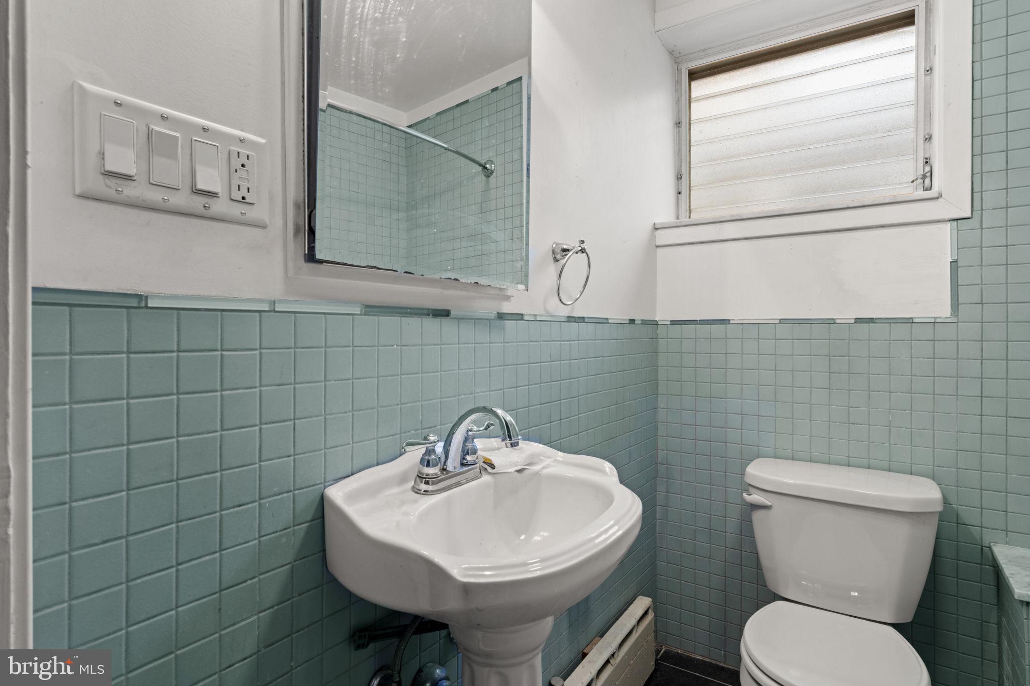 3633 Warren Street Philadelphia, PA 19104 - Photo 20 of 38 a bathroom with a toilet sink and mirror