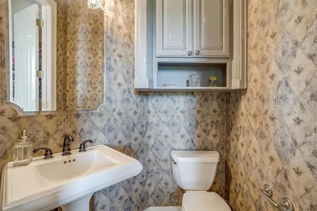 a bathroom with a sink a toilet and mirror