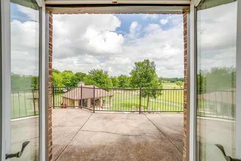 a view of a balcony with a floor to ceiling window with wooden fence