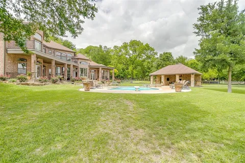 a front view of a house with garden and trees