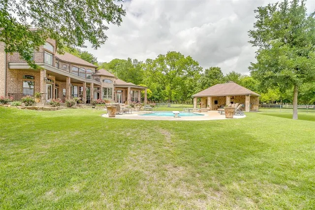 a front view of a house with garden and trees