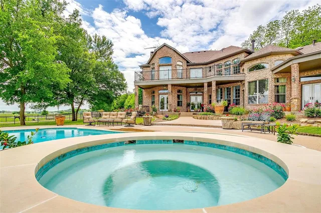 a view of a swimming pool with outdoor seating and a big yard
