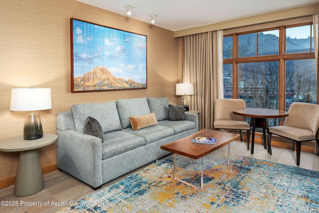 a living room with furniture a rug and a lamp