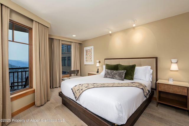 a large bed sitting in a bedroom next to a window