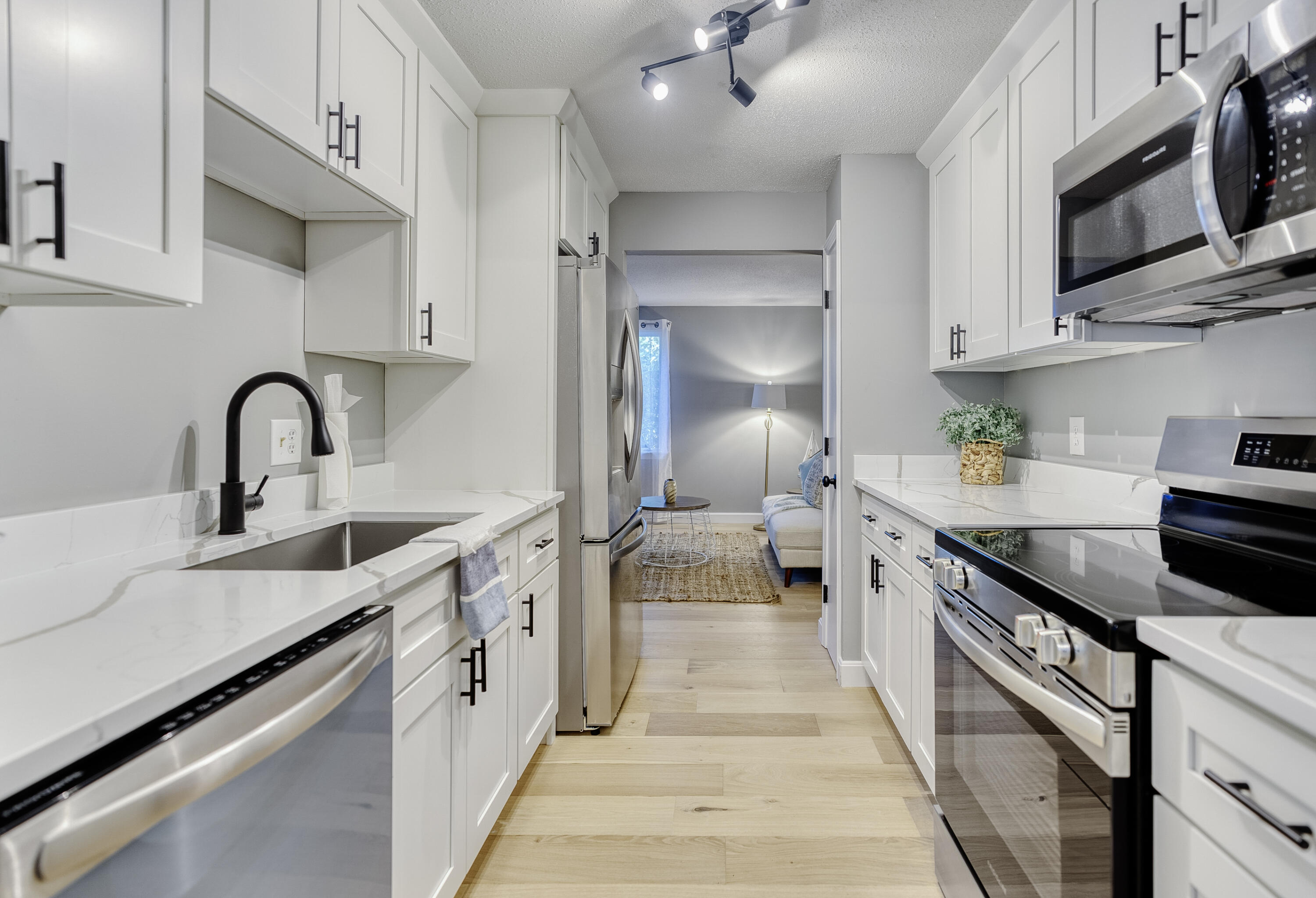 32 Sandy Reach Teaticket, MA 02536 - Photo 8 of 25 a kitchen with stainless steel appliances a sink dishwasher stove refrigerator and cabinets with wooden floor
