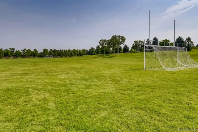 a view of swimming pool with lawn chairs under an umbrella