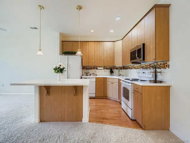 a kitchen with a sink a counter top space stainless steel appliances and cabinets