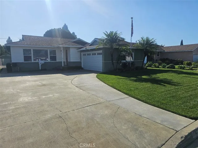 a front view of a house with a garden and yard