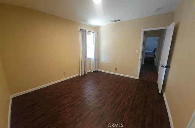 an empty room with wooden floor and closet