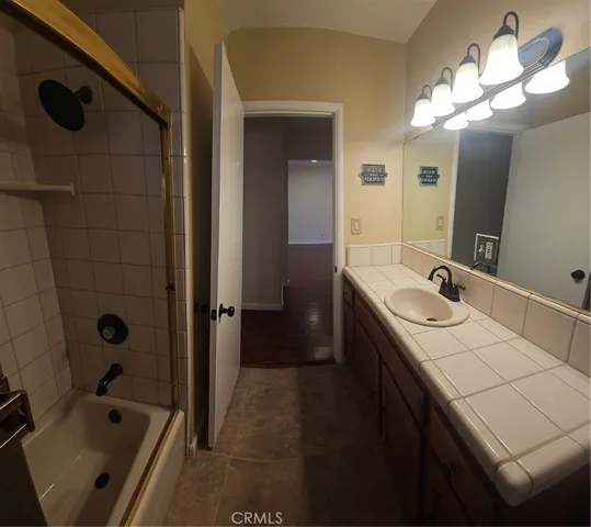 a bathroom with a double vanity sink a mirror and a bathtub