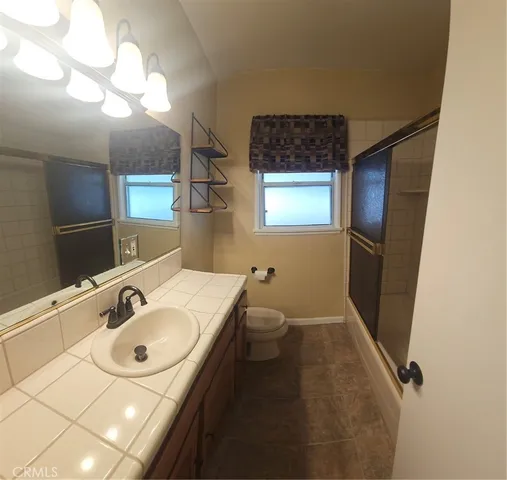 a bathroom with a sink a toilet a mirror and vanity