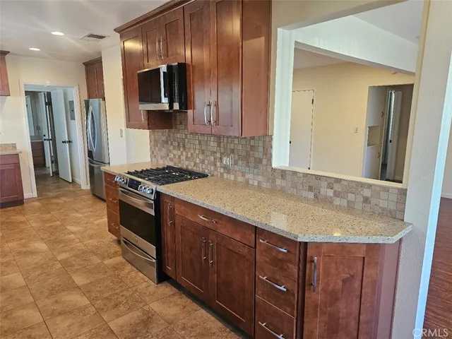 a kitchen with stainless steel appliances granite countertop a sink and a stove