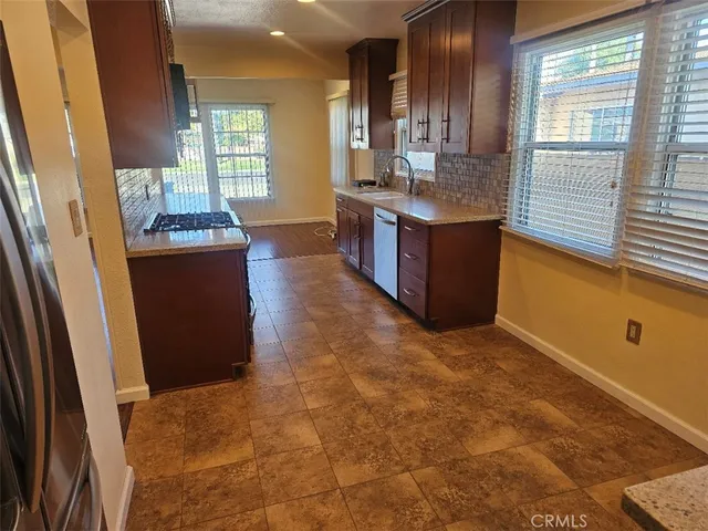 a kitchen with granite countertop a sink stove and cabinets