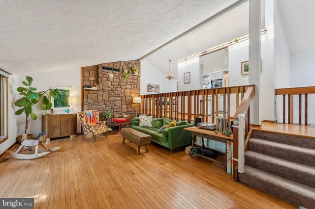 a living room with furniture floor to ceiling window and wooden floor