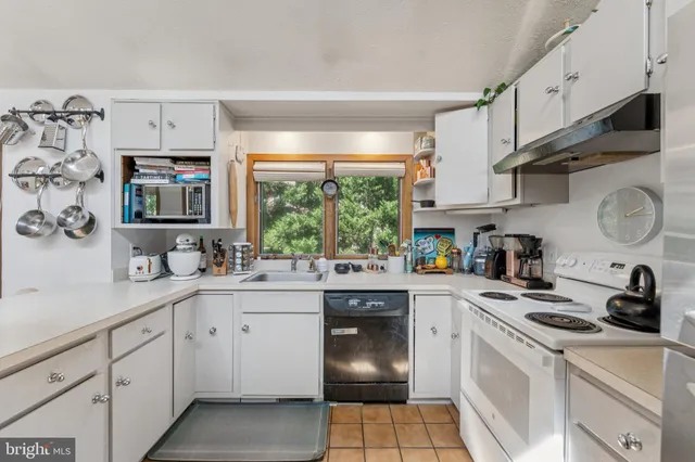 a kitchen with stainless steel appliances a white stove top oven sink and cabinets
