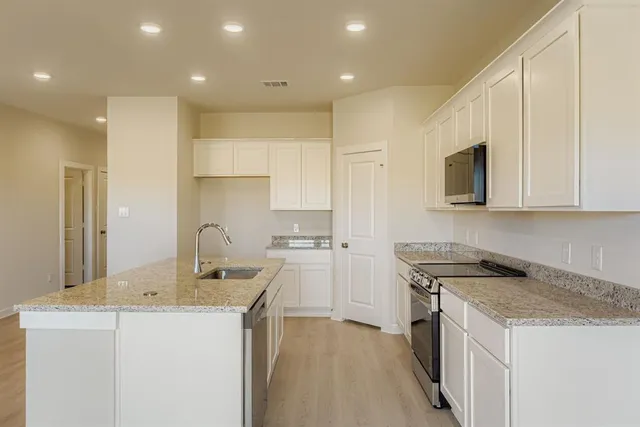 a kitchen with a sink stove and cabinets