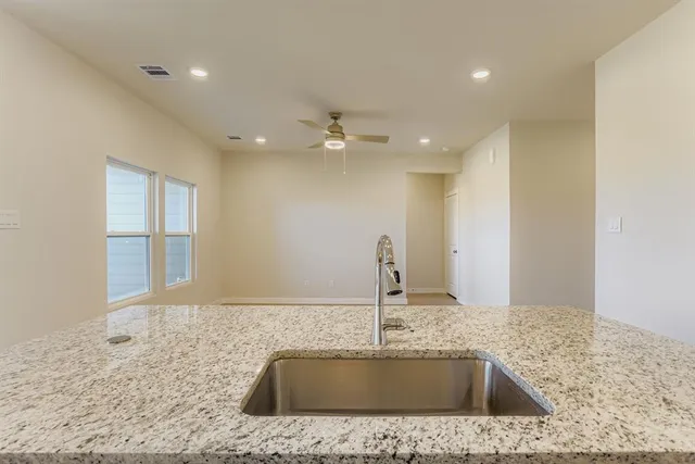 a kitchen with kitchen island a sink and a stove top oven with wooden floor