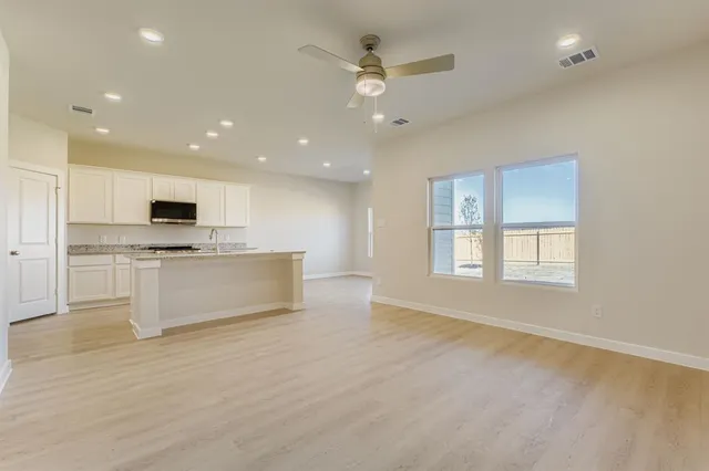 a view of kitchen with kitchen island white cabinets and stainless steel appliances
