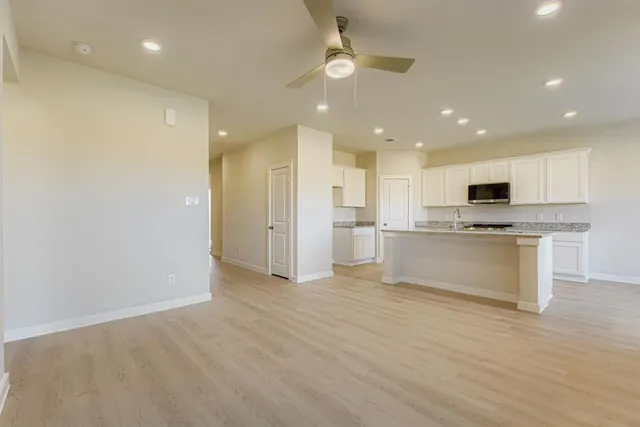 a view of kitchen with kitchen island granite countertop stainless steel appliances refrigerator and microwave