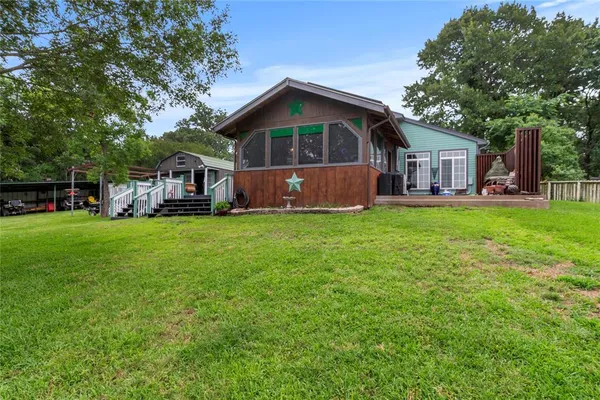 a front view of a house with a yard deck and trees