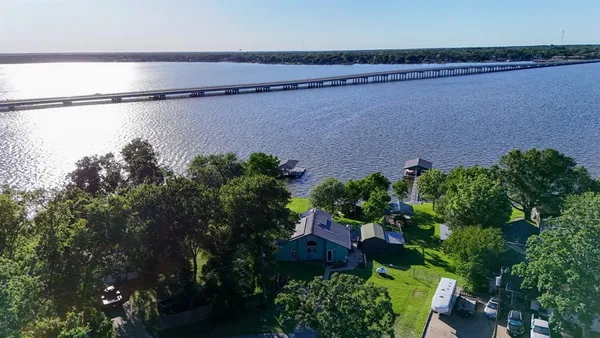 an aerial view of a house with a yard and lake view