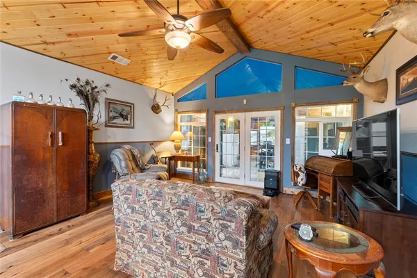 a living room with furniture a flat screen tv and floor to ceiling window
