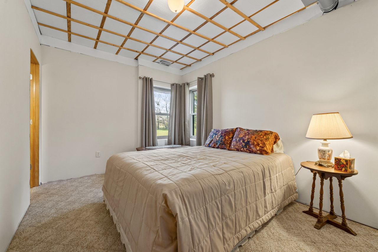 18508 128th Street Bristol, WI 53104 - Photo 35 of 48 a bedroom with a bed and a chandelier