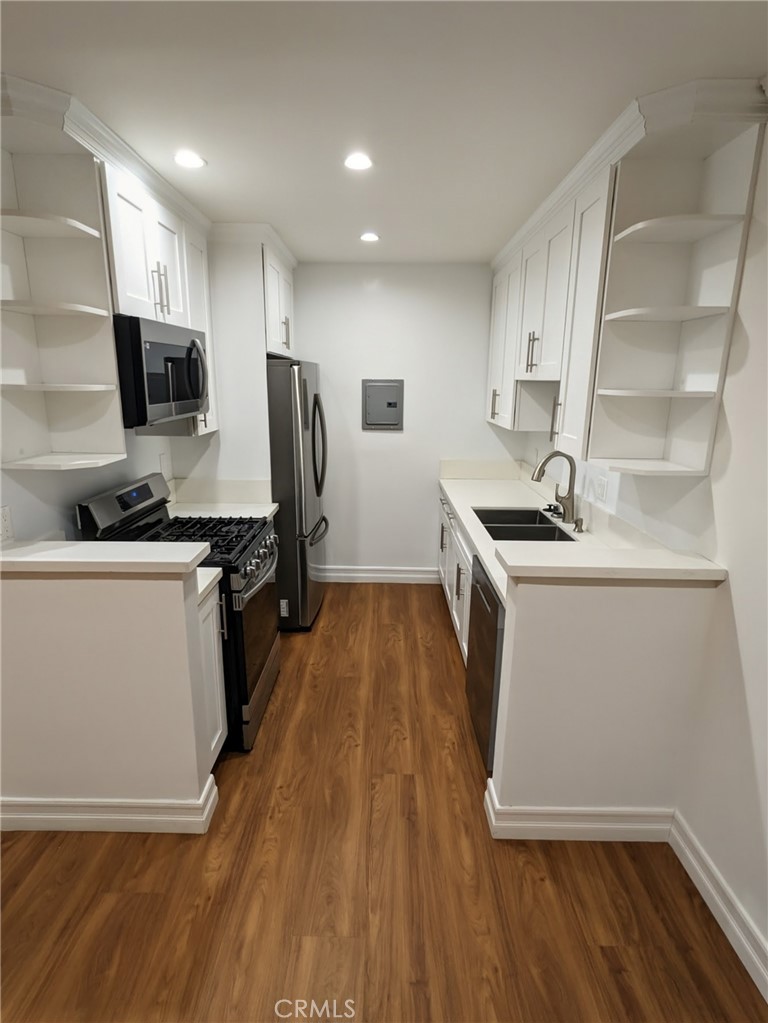 1019 6th Street, Unit 2 Santa Monica, CA 90403 - Photo 4 of 15 a kitchen with a sink a microwave oven a stove and white cabinets