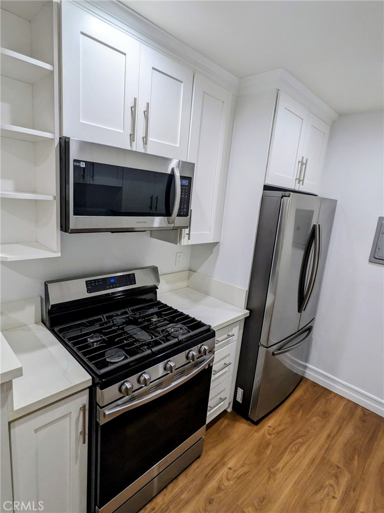 1019 6th Street, Unit 2 Santa Monica, CA 90403 - Photo 7 of 15 a kitchen with granite countertop a stove and a microwave