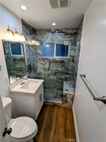 a bathroom with a sink a toilet and shower