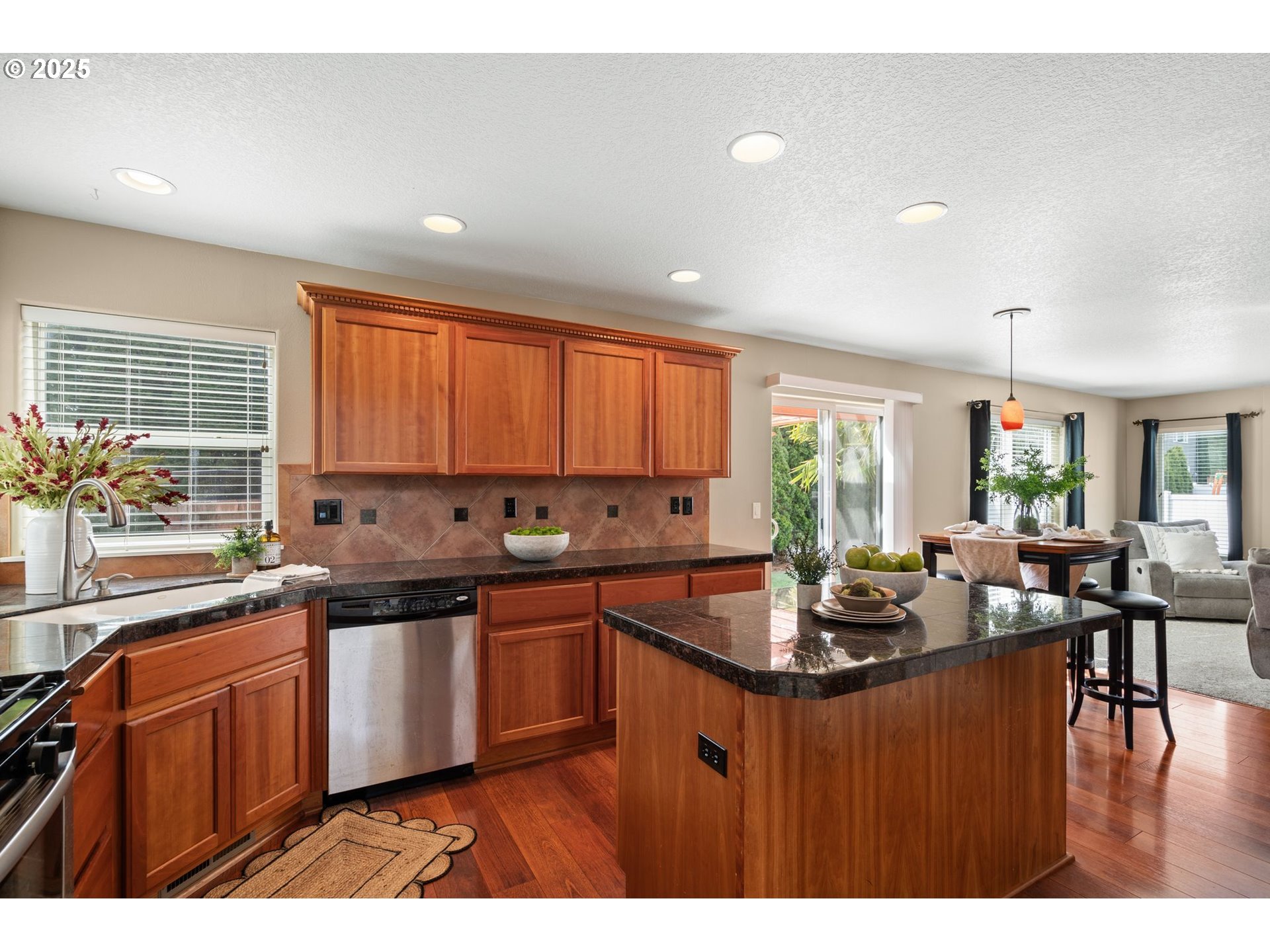 2597 North Lambert Street Cornelius, OR 97113 - Photo 12 of 48 a kitchen with stainless steel appliances granite countertop wooden cabinets a stove a sink a dining table and chairs