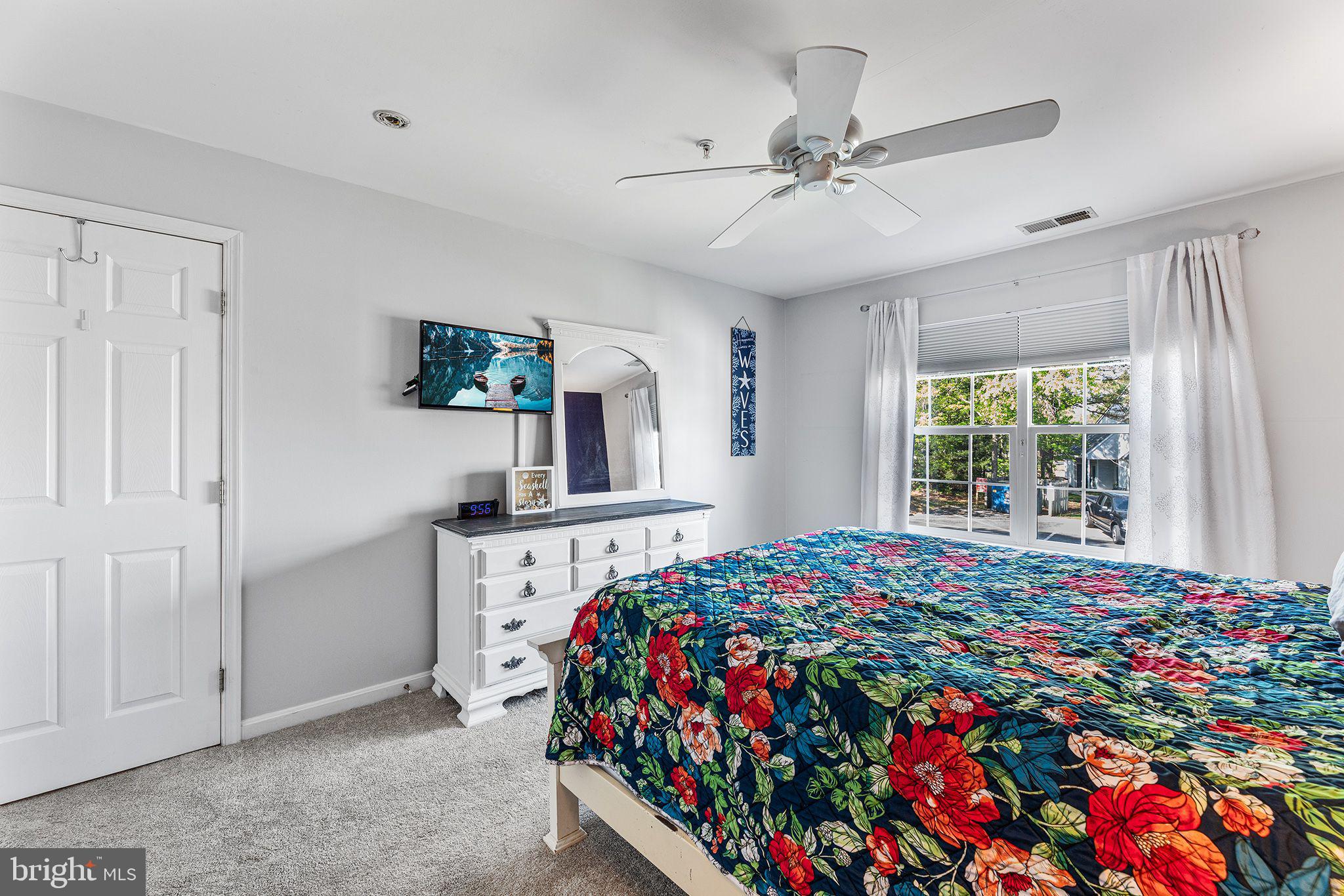 11431 Manklin Creek Road, Unit 5 Berlin, MD 21811 - Photo 15 of 38 a bedroom with a bed a dresser next to a window
