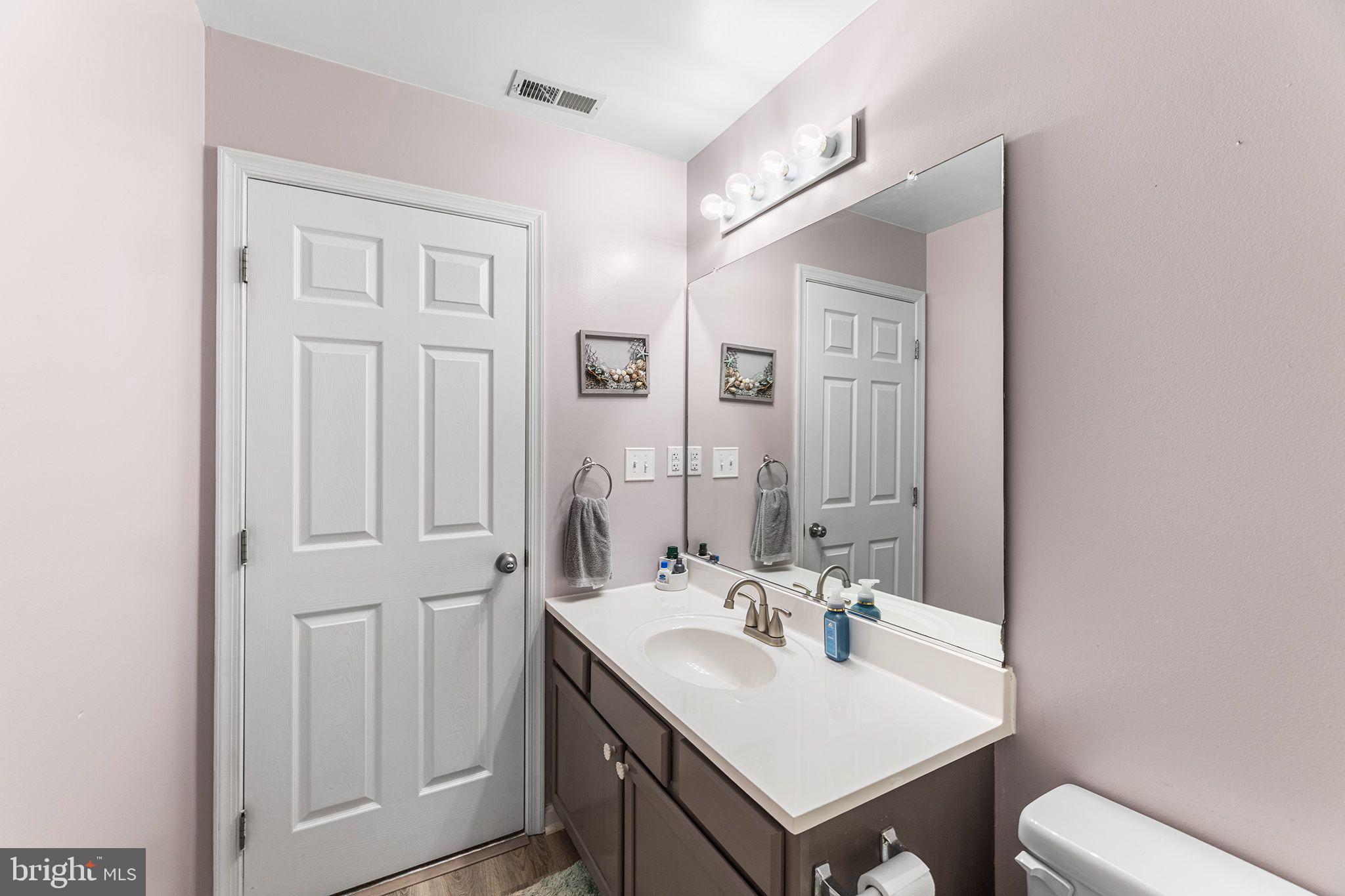 11431 Manklin Creek Road, Unit 5 Berlin, MD 21811 - Photo 25 of 38 a bathroom with a sink a toilet and a mirror