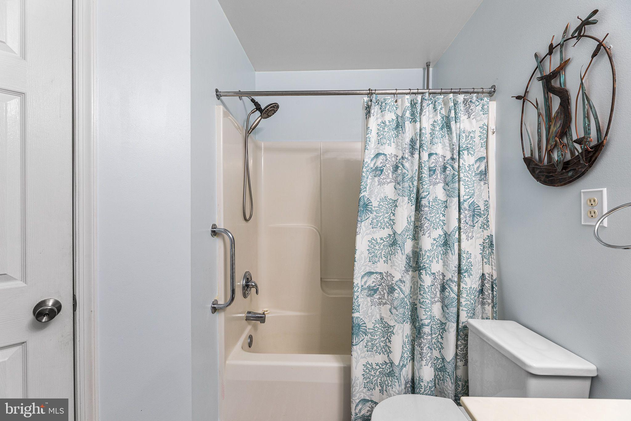 11431 Manklin Creek Road, Unit 5 Berlin, MD 21811 - Photo 34 of 38 a bathroom with a shower curtain and a toilet