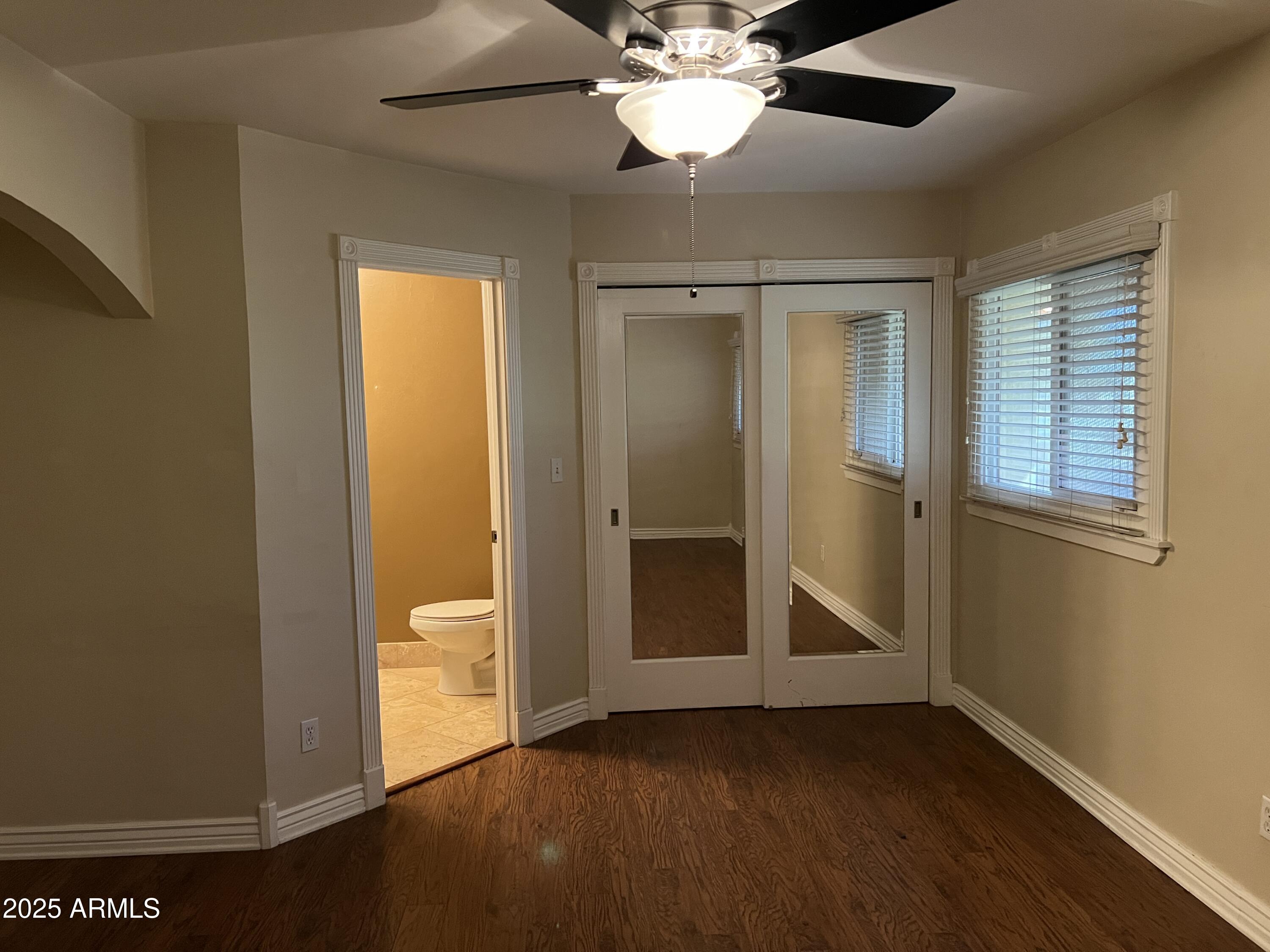 4573 South Mill Avenue Tempe, AZ 85282 - Photo 18 of 32 an empty room with wooden floor fan and windows
