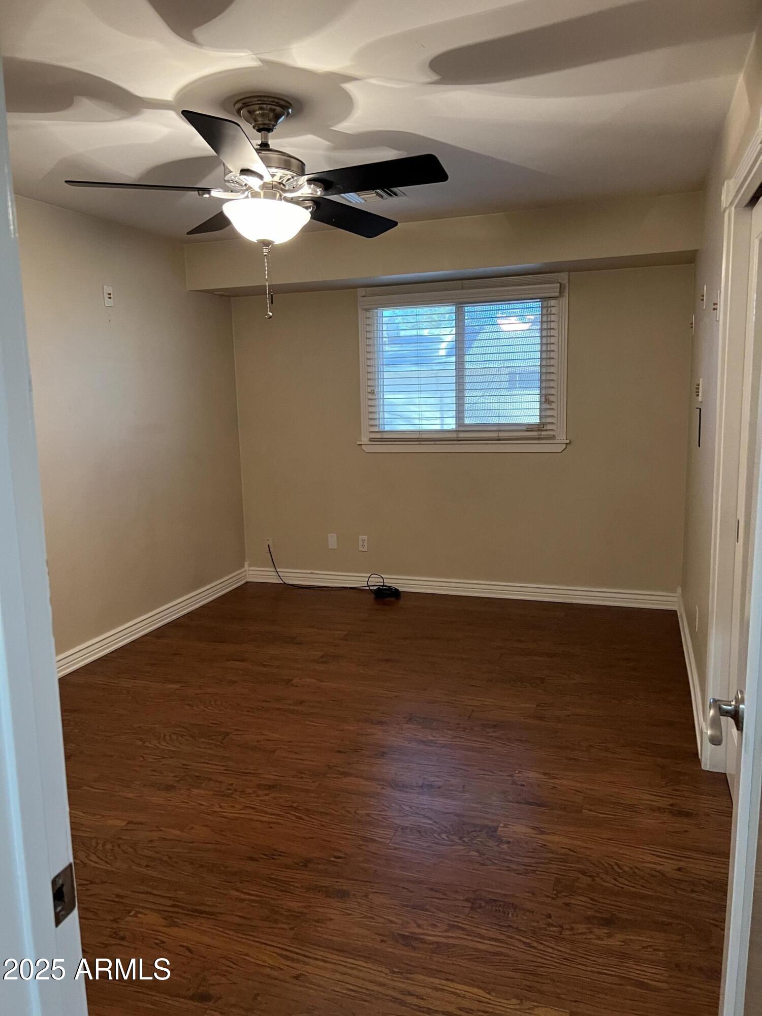 4573 South Mill Avenue Tempe, AZ 85282 - Photo 22 of 32 a view of an empty room with wooden floor and a window