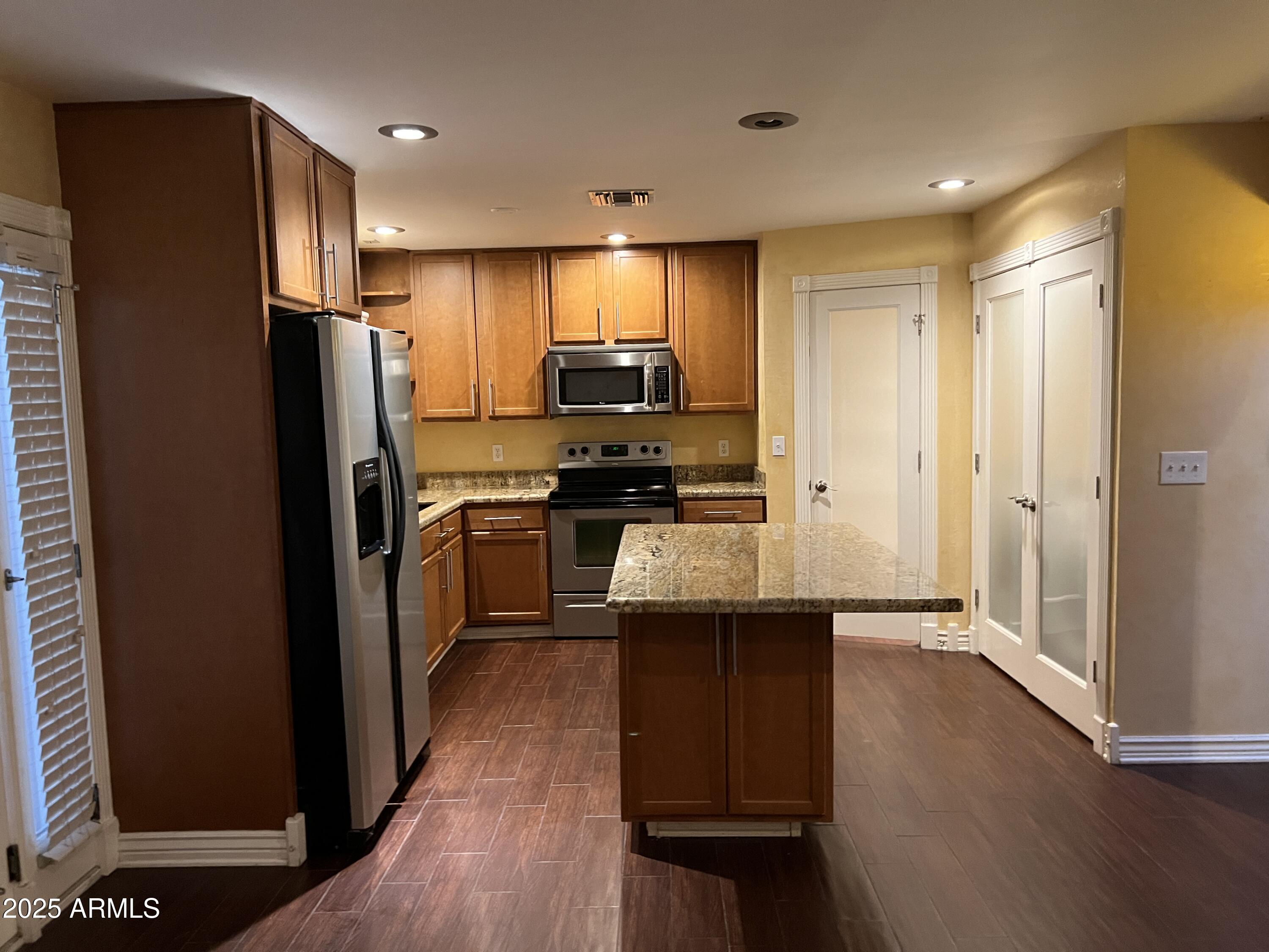 4573 South Mill Avenue Tempe, AZ 85282 - Photo 6 of 32 a kitchen with stainless steel appliances granite countertop a refrigerator a sink and wooden cabinets