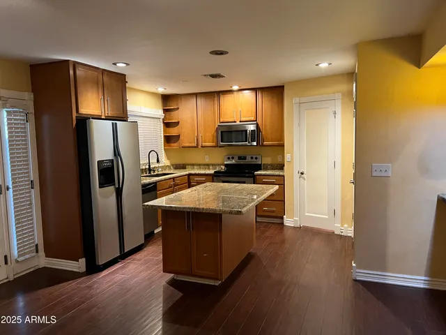 a kitchen with a refrigerator sink and cabinets