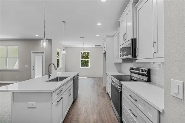 a kitchen with stainless steel appliances a sink stove and cabinets