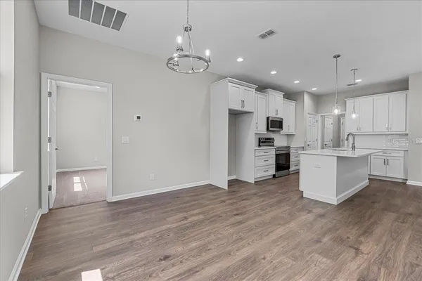 a view of kitchen with granite countertop cabinets and refrigerator