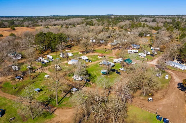 an aerial view of residential houses with outdoor space and lake view