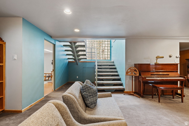 1856 Fort Canyon Road Alpine, UT 84004 - Photo 26 of 49 Carpeted living area featuring recessed lighting, a sliding door opening to wood-finish flooring, a staircase with glass block accents, and light blue wall details