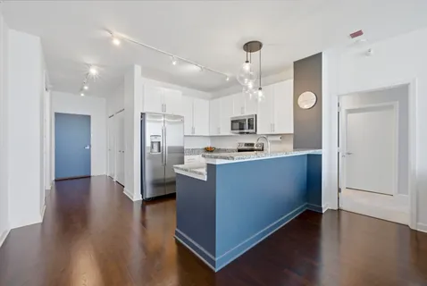 a kitchen with kitchen island granite countertop a sink a counter space and cabinets