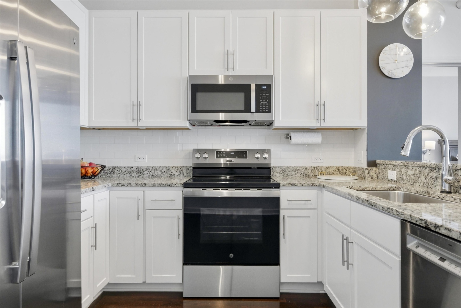 1629 South Prairie Avenue, Unit 2709 Chicago, IL 60616 - Photo 18 of 37 a kitchen with stainless steel appliances granite countertop a stove a microwave and a white cabinets