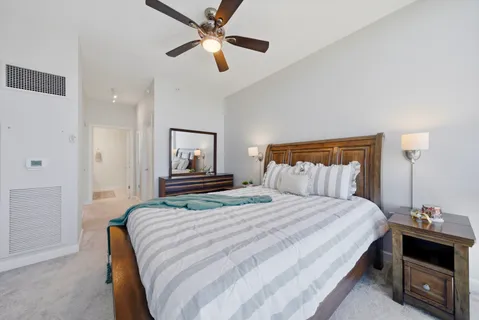 a spacious bedroom with a bed and a ceiling fan