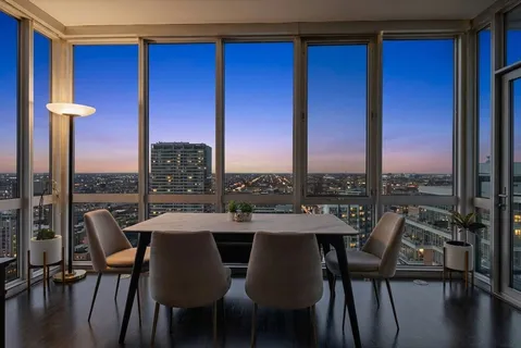 a view of a city from a dining room with furniture and window