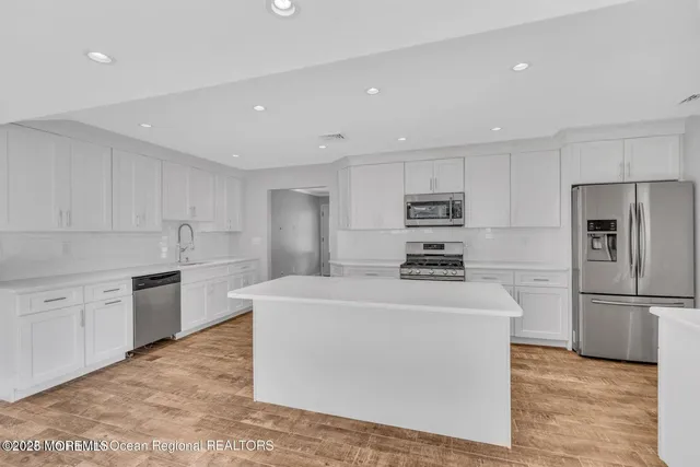 a kitchen with granite countertop white cabinets and sink