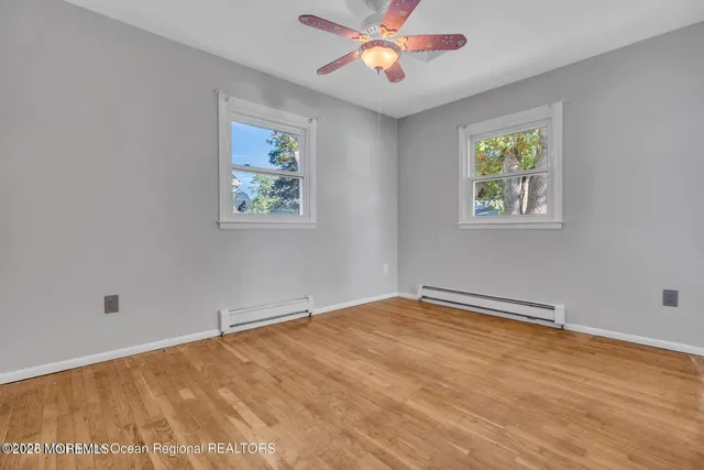 a view of an empty room with a chandelier fan