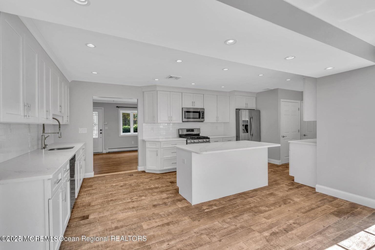 2253 Llewellyn Parkway Forked River, NJ 08731 - Photo 8 of 42 a large white kitchen with stainless steel appliances granite countertop a sink a stove and a refrigerator